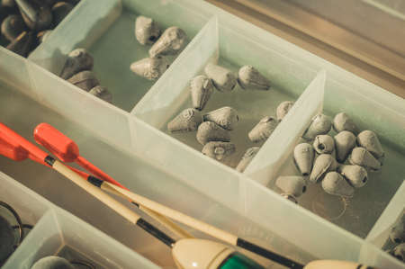 Box with a set of fishing sinkers. Lead sinkers of different weights. Equipment and accessories for fishing. Selective focus.の写真素材