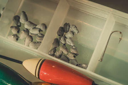 Box with a set of fishing sinkers. Lead sinkers of different weights. Equipment and accessories for fishing. Selective focus.の写真素材