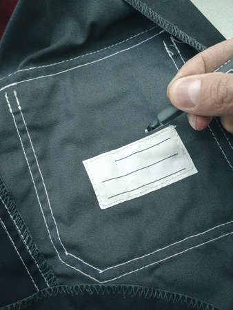 Patch on work clothes to write the name of the owner. Close-up of a clean name patch. Name tag. Selective focus, grainの写真素材
