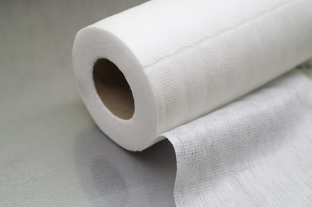 Universal white fabric napkins for cleaning in a roll. Bobbin with napkins for dispenser. Selective focusの写真素材