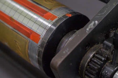 A fragment of the machine for sticking flexo forms on the cylinders of the printing press. Printing equipment. Dust and dirt on equipment parts. Selective focus.の写真素材
