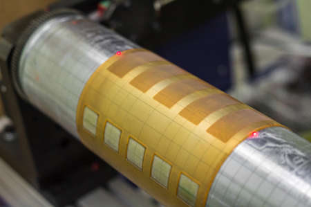 Close-up of the cylinder with glued flexographic printing form from a photopolymer. Preparation of equipment for printing self-adhesive labels. Selective focusの写真素材