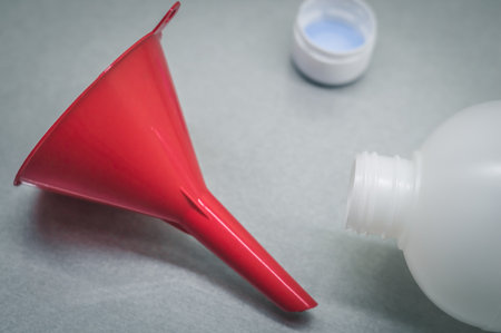 Red funnel and plastic bottle. Selective focus, copy spaceの写真素材