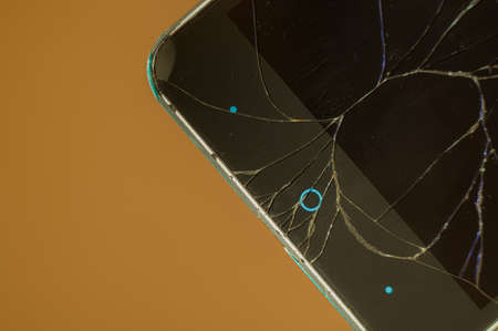 Smartphone with broken display glass. Cracked screen glass. Broken phone. Selective focusの写真素材
