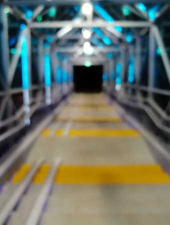 Blurred pedestrian bridge at night. LED illumination. Abstract background with night lights. Defocused.の写真素材