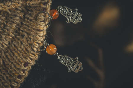 Decorative markers for knitting. Metal and stone. Hand knitting. Dark background, close-up, copy space, horizontal compositionの写真素材
