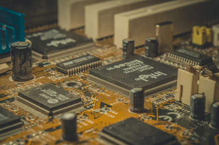 RUSSIA, BERDSK - 2021: Intel computing chip on an old motherboard. Old electronics close-up. Chip ISSI, UMC. Selective focus, dustのeditorial素材