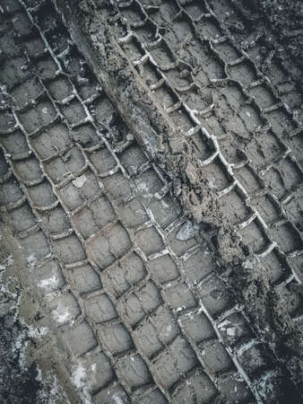 Traces of truck tires on a dirt road covered with mud and melted snow. Selective focusの写真素材