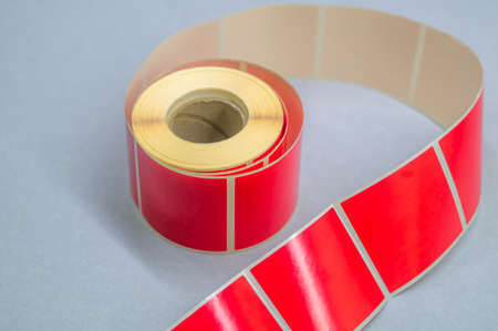 Roller tape red self-adhesive label. Material for printing and marking products. Thermal label. Selective focus, copy spaceの写真素材