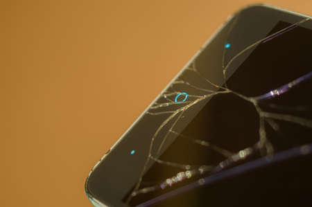 Smartphone with broken display glass. Cracked screen glass. Broken phone. Selective focusの写真素材