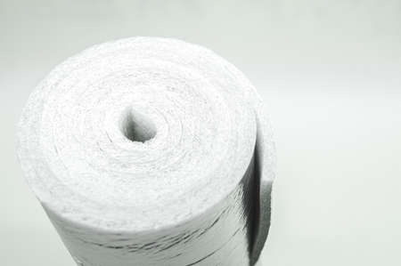 A roll of insulation made of foamed polyethylene with aluminum foil. Thermal insulation with reflective foil. Selective focus, copy spaceの写真素材