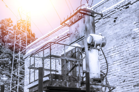 Old high-voltage transformer of city power supply. Rusty equipment of the power plant. Selective...