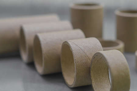Cardboard spools for winding. Reels made of cardboard. Background of cardboard bobbins. Selective focus.の写真素材