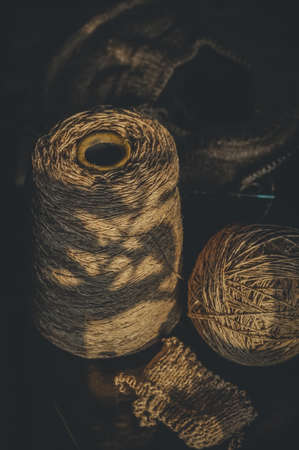 Bobbin yarn, with a ball and a started knitting project. Yarn for knitting. Vertical composition, black backgroundの写真素材