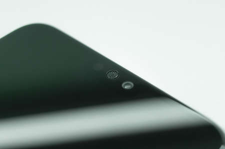 Smartphone micro speaker above the screen close-up. The top of the mobile phone with a built-in camera and speaker. Selective focusの写真素材