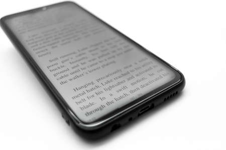 Berdsk, Russia - 7.12.2021: E-book Star Wars - Empire strike back on the screen of a smartphone. Reading electronic books on your mobile phone. The text on the screen. Selective focus, copy spaceのeditorial素材