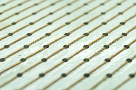 Back side of the brush for washing equipment. Close-up. Perforated surface with rows of threads. Selective focus, abstract backgroundsの写真素材