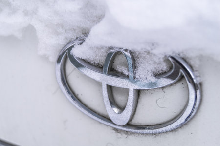 Berdsk, Russia - 17 jan 2022: Old Toyota logo in the snow. The Toyota companys logo on a used car. Close-up, selective focusのeditorial素材