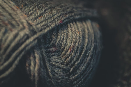 Close-up of a ball of tweed yarn on a black background. Natural yarn made of wool. Hand knitting. Hobby. Selective focusの写真素材