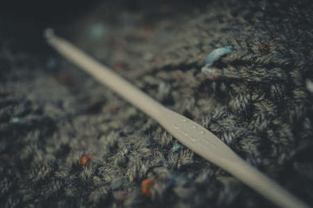 Knitting hook 300mm. Natural yarn made of wool. His hobby is hand knitting. Selective focus, black backgroundの写真素材