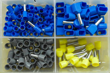 A set of colored crimp terminals for electrical wires. Crimping sleeves of different sizes. Plastic spare parts box for electrician. Toolbox. Selective focusの写真素材