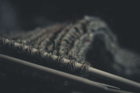 Knitting wool sock. Natural yarn made of wool. His hobby is hand knitting. Selective focus, black backgroundの写真素材