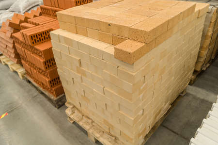 Yellow facing brick on a pallet. Bricks in a construction material store. Selective focusの写真素材