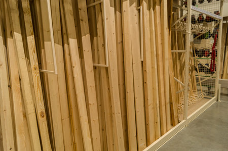A vertical row of boards in a hardware store. Wooden products for construction and repair....