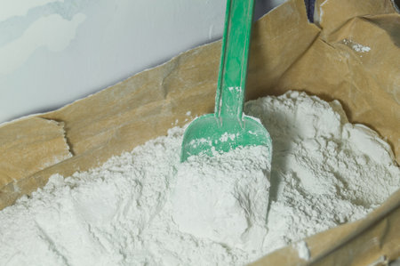 White plaster in an open paper bag. Finishing dry mixture for leveling walls and ceilings. Repair in the house with your own hands. DIY. Selective focusの写真素材