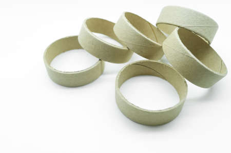 Narrow cardboard spools for winding rolled materials and self-adhesive labels. Reels made of cardboard for printing houses. Selective focus, isolated on whiteの写真素材
