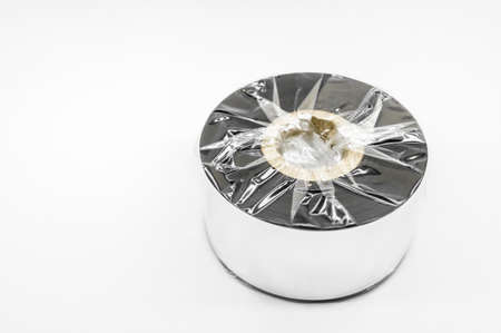 Single thermal transfer ribbon - TTR. Wax thermo ribbon on cardboard reel for barcode. Supply material for printing industry. Selective focus, isolated on whiteの写真素材