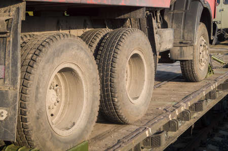 A truck is fixed on the railway platform of a freight train. Transportation of cars and equipment by rail. Selective focusの写真素材