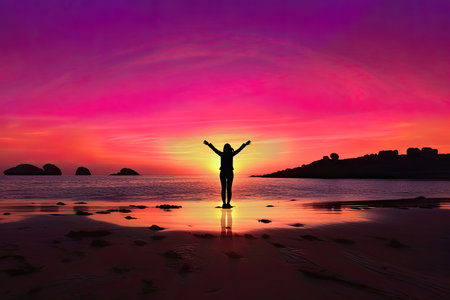 silhouette of woman standing on the beach with sunset backgroundの素材