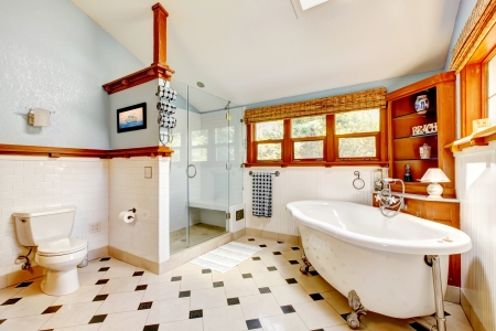 Large classic blue bathroom interior with tub and tiles and wood cabinets.の写真素材