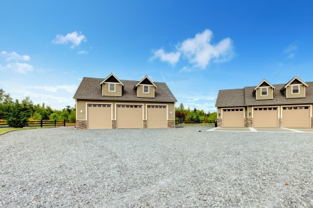 Large farm country house with gravel driveway and green landscape.の写真素材