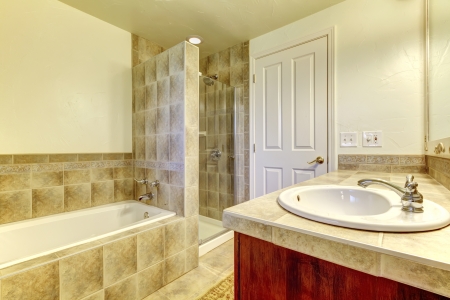 Bathroom with tub,  small shower and wood cabinets.の写真素材