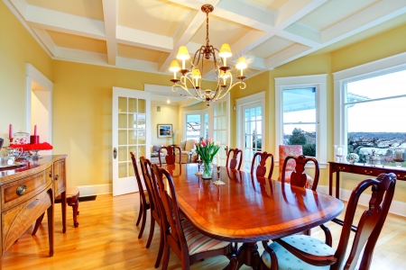 Golden bright yellow luxury dining room with elegant classic furniture and white wood ceiling.の写真素材