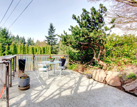 Roof top deck over garage with a concrete floor and patio table set. Landscaping design idea