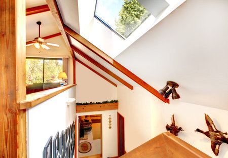 Log cabin house interior  View of ceiling with beams and velux window from loft office staircase