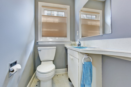 Small light blue bathroom inteiror in old house. View of white wooden bathroom vanity cabinet with mirrorの写真素材