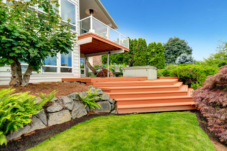 House exterior with beautiful landscape design. View of walkout deck with stairs