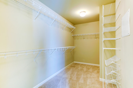 Bright ivory empty walk-in closet with shelvesの写真素材