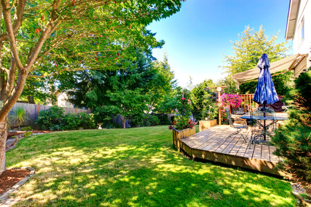 Walkout deck with patio table and umbrella overlooking backyard gadenの写真素材