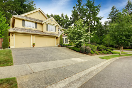 House exterior with two car garage and driveway. Beautiful landscape