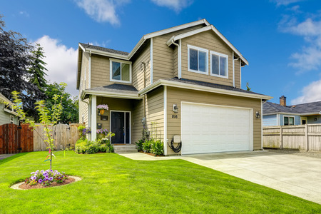 Two story house exterior with white door garage and driveway