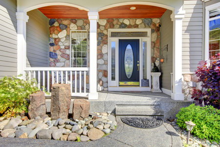 Modern house with navy blue door, and decorative front yard.