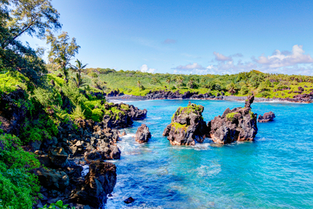 Waves breaking on the rocks on a sunny day during a spectacular ocean view on the Road to Hana, Maui, Hawaii, USAの写真素材