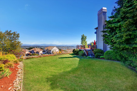Spacious back yard with grass filled garden and amazing view. House exterior.