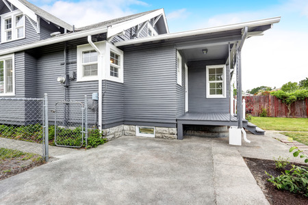 Backyard house exterior with siding trim, wooden floor porch and concrete walkway. Northwest, USAの写真素材