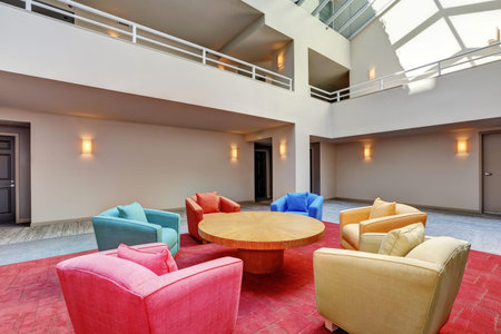 Lounge, common area with colorful armchairs and red carpet in apartment building.  Interior design....